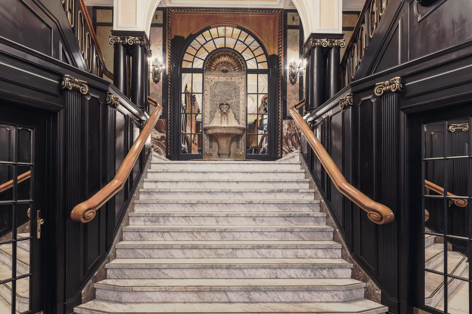 A grand marble staircase in a dark, panelled hall.