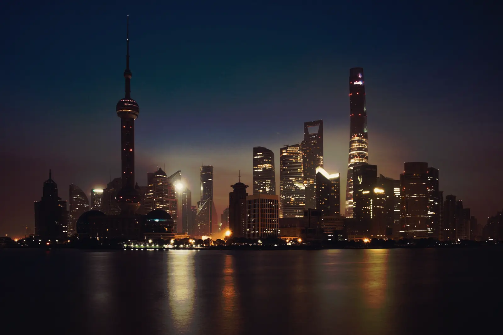 The Pudong skyline across the Huangpu River at blue hour.